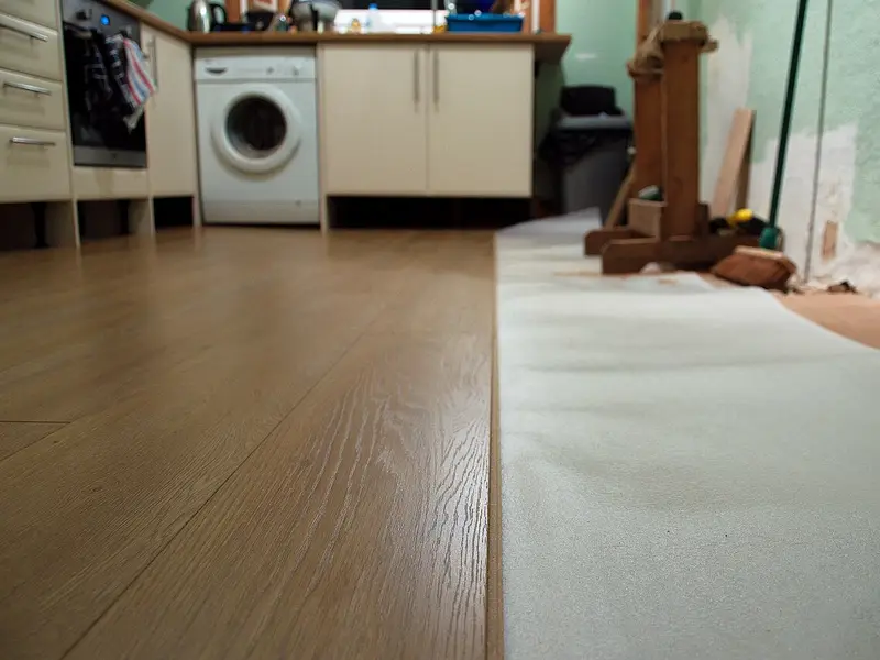 Cocina con un suelo de lamas claras en plena instalación
