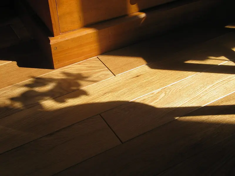 Parquet macizo de roble rústico con bisel iluminado por el sol