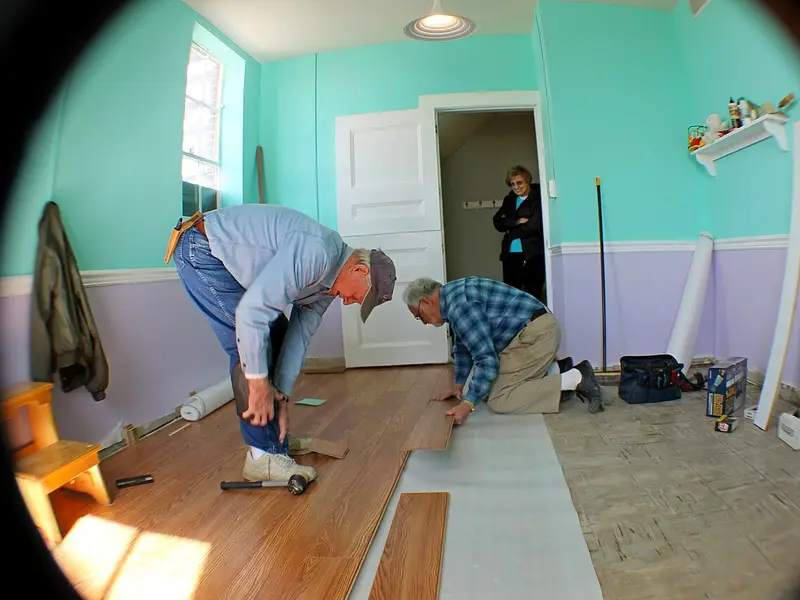 Instaladores colocando un suelo laminado en una habitación