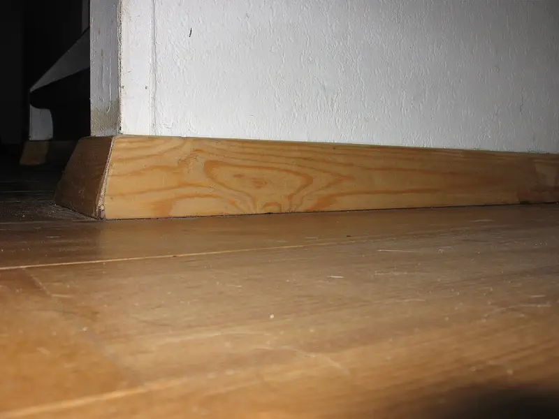Suelo de madera clara con rodapié de madera