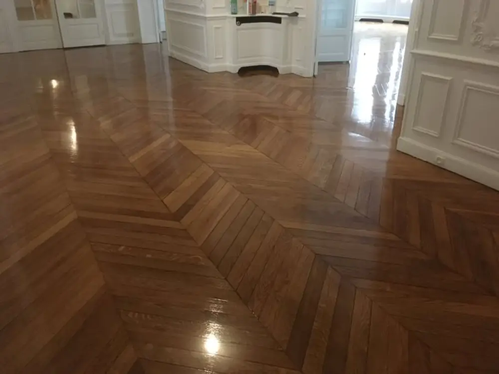 Suelo de madera con acabado barnizado reflejando la luz