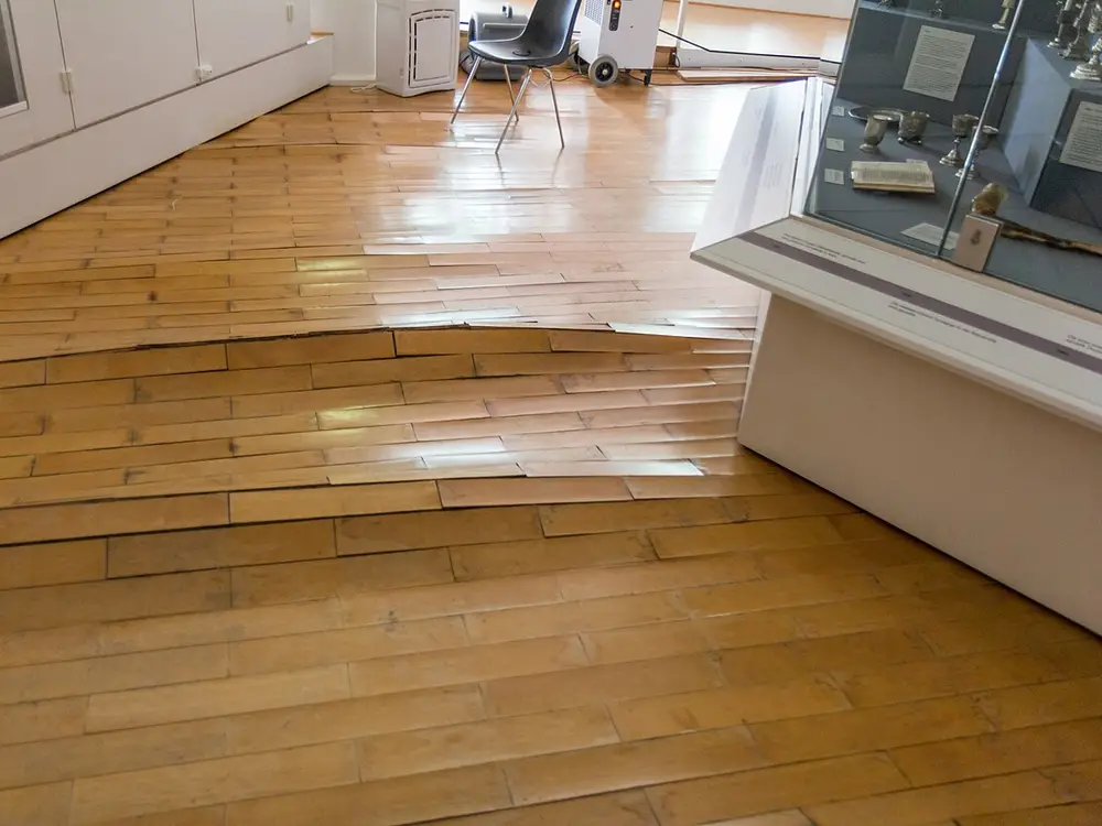 Detalle de parquet desgastado con zonas deterioradas que necesitan reparación