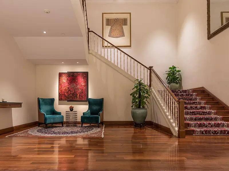 Salón amplio con suelo de madera brillante y escalera