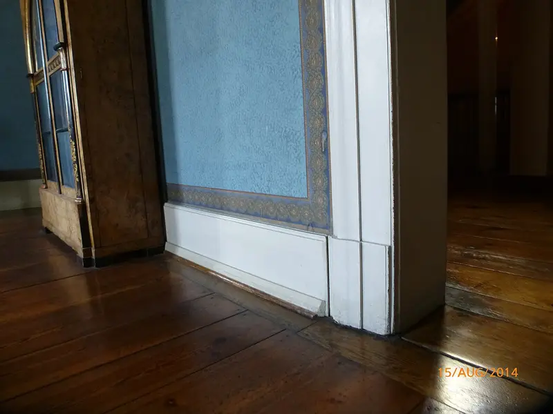 Suelo antiguo de tablas de madera junto a una puerta